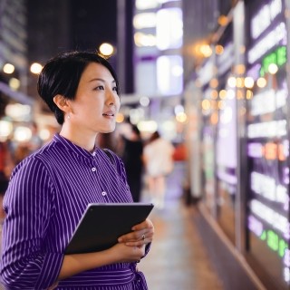 Woman standing in front of illuminated wall