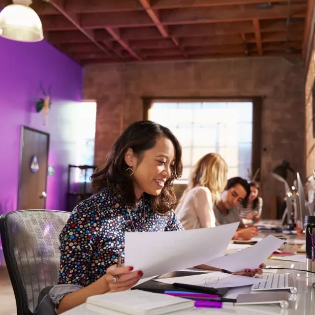 A smiling woman in a busy office