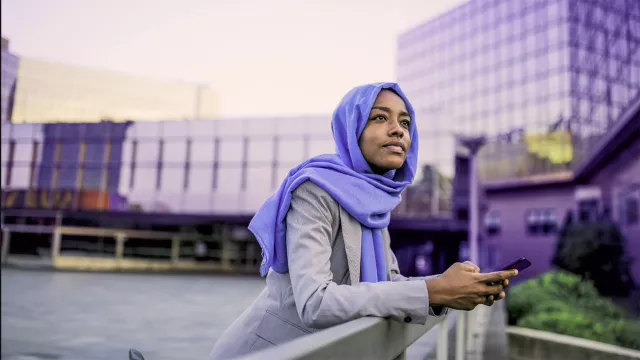 Image of woman holding phone outdoors