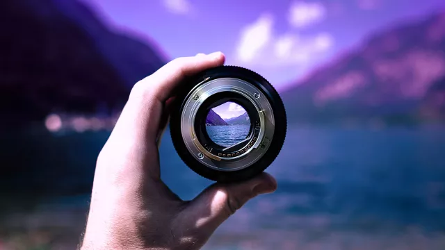 Image of a hand holding a camera lens