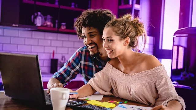 Image of man and woman browsing in their laptop at home