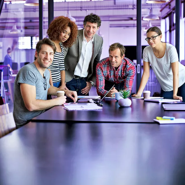 Image of coworkers standing at the desk