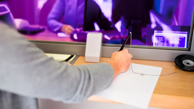 Image of arm and hand signing document