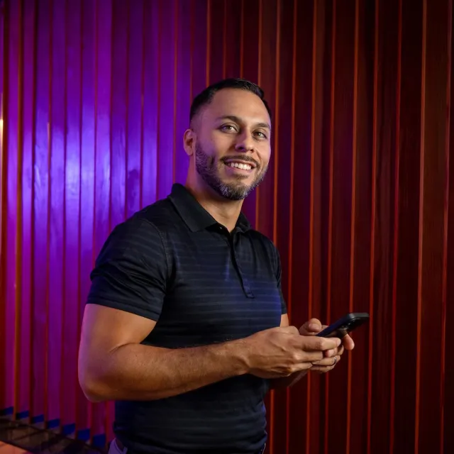 Image of man smiling, holding phone