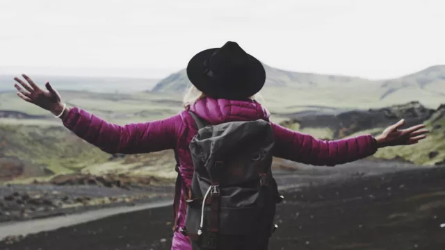 Woman with arms out looking at landscape