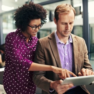 man and woman pointing at tablet