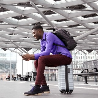 man smiling at phone in airport