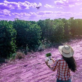 Image of woman flying a drone on a field