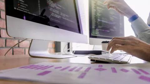 Hands typing at computer