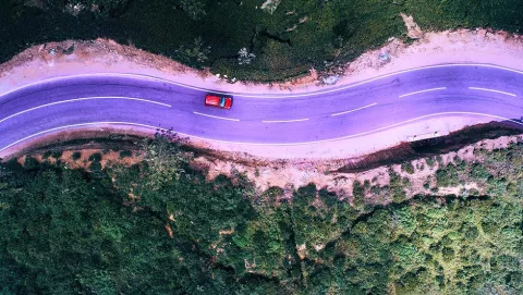 Image of road with car driving through it